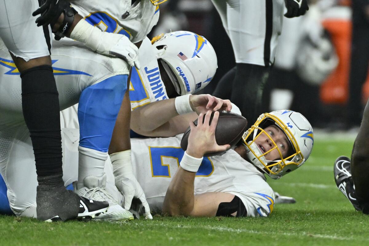 Chargers quarterback Easton Stick is tackled.
