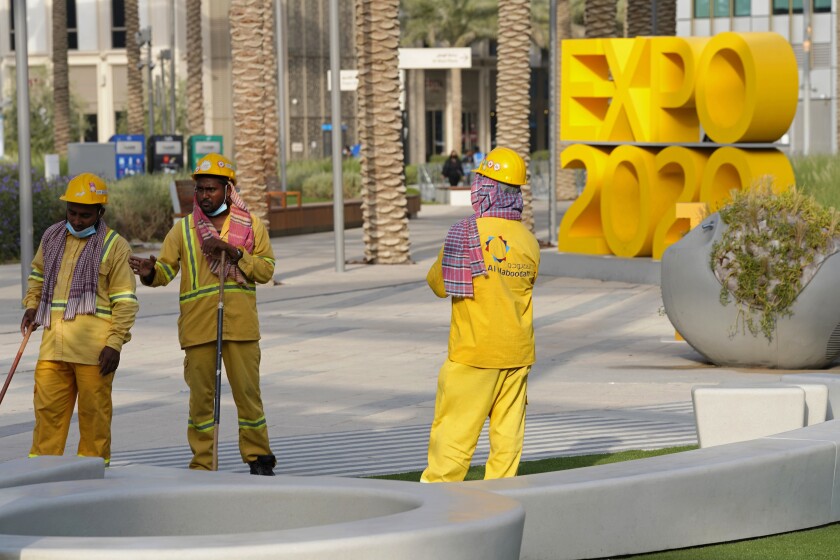 Trabajadores de la limpieza en acción en la Expo 2020 de Dubái el 3 de octubre del 2021. Abundan las denuncias de abusos de los trabajadores en la feria mundial. (AP Photo/Jon Gambrell, File)