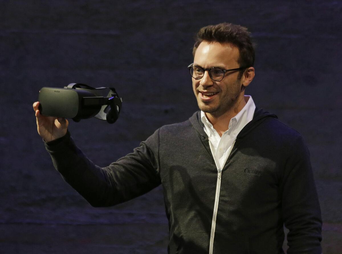 In June, Oculus VR Chief Executive Brendan Iribe holds up the new Rift virtual reality headset during a news conference in San Francisco.