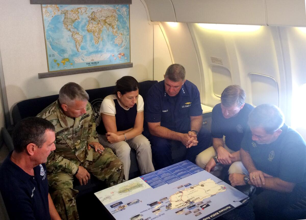 Acting Homeland Secretary Elaine Duke, center, is briefed on the Hurricane Maria response during a flight to Puerto Rico.