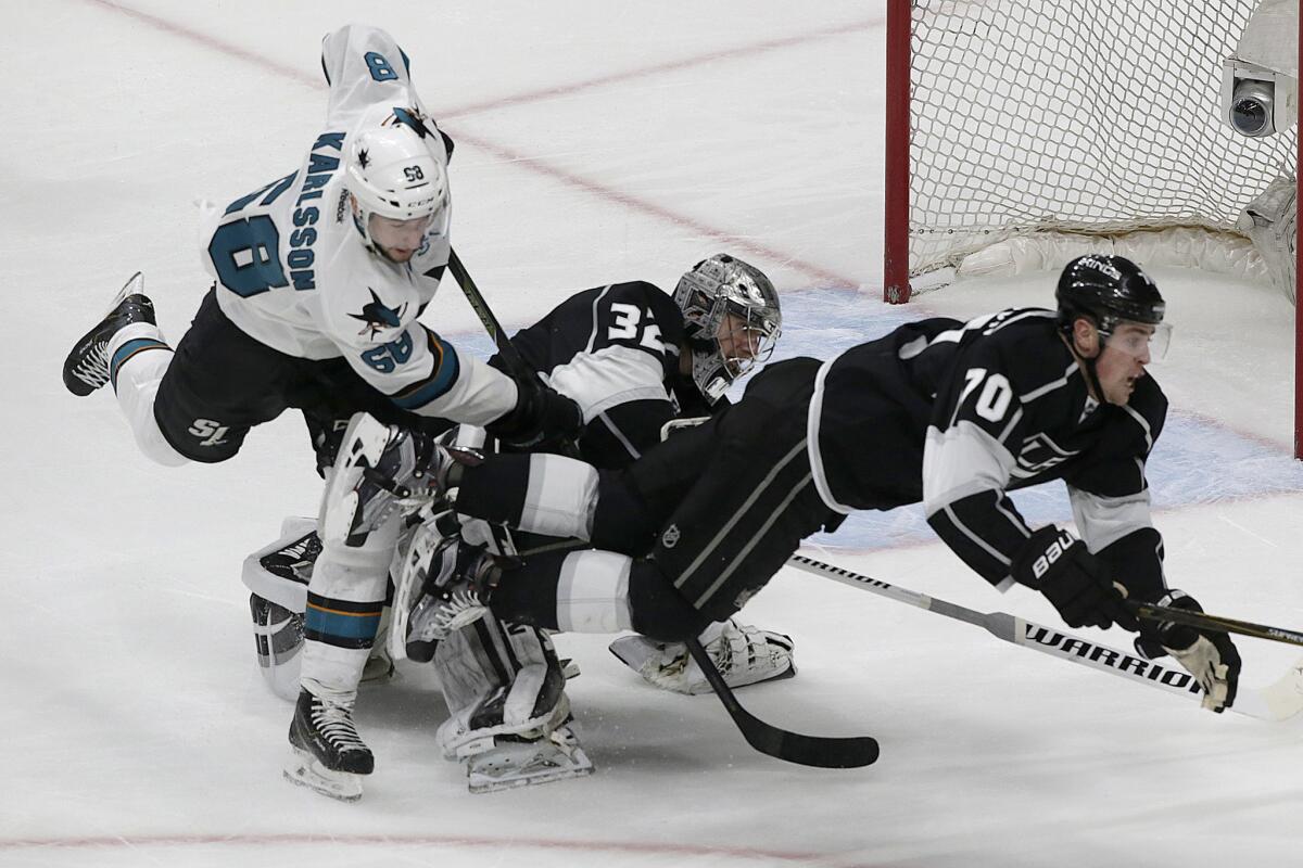 Kings forward Tanner Pearson and goalkeeper Jonathan Quick collide with Sharks center Melker Karlsson as they battle for a loose puck during the third period.