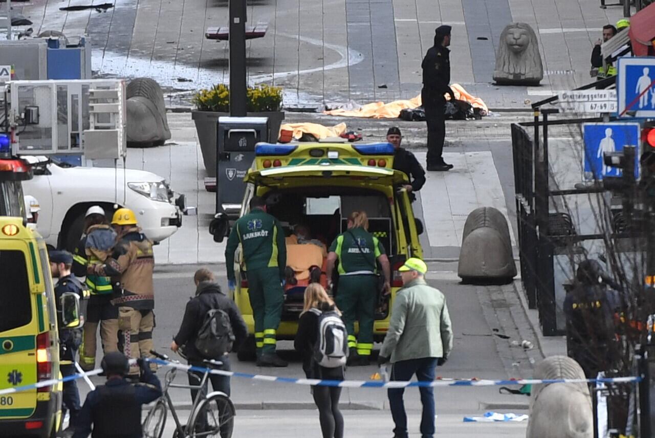Emergency services personnel work at the scene where a truck crashed into the Ahlens department store in central Stockholm on Friday.