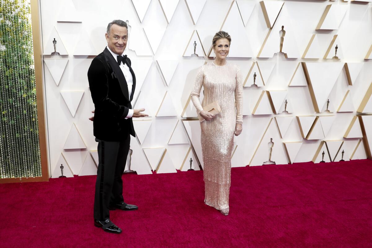 Tom Hanks gestures toward his wife, actress Rita Wilson, on the red carpet at the 92nd Academy Awards.