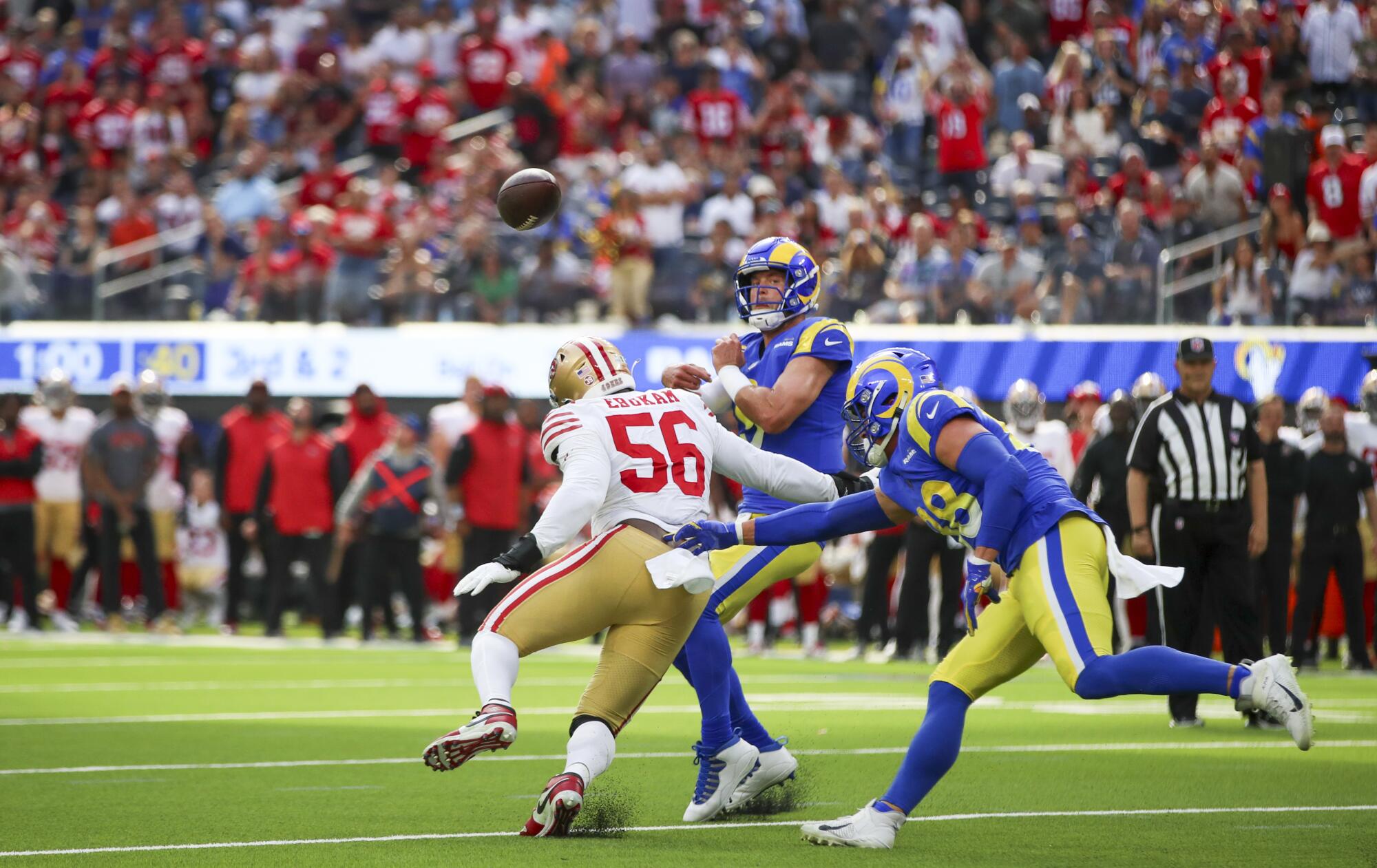 Rams quarterback Matthew Stafford throws the ball under pressure from 49ers defensive lineman Samson Ebukam.