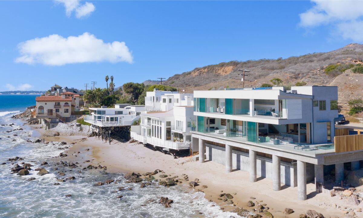 A two-story home overlooks the ocean.