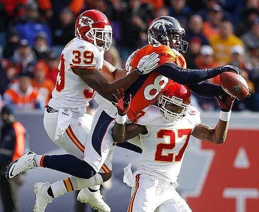 Denver Broncos wide receiver Brandon Lloyd goes over the top of Kansas City Chiefs cornerback Donald Washington to catch a pass for a first down in the first quarter in Denver. Also defending for the Chiefs is Brandon Carr (39).