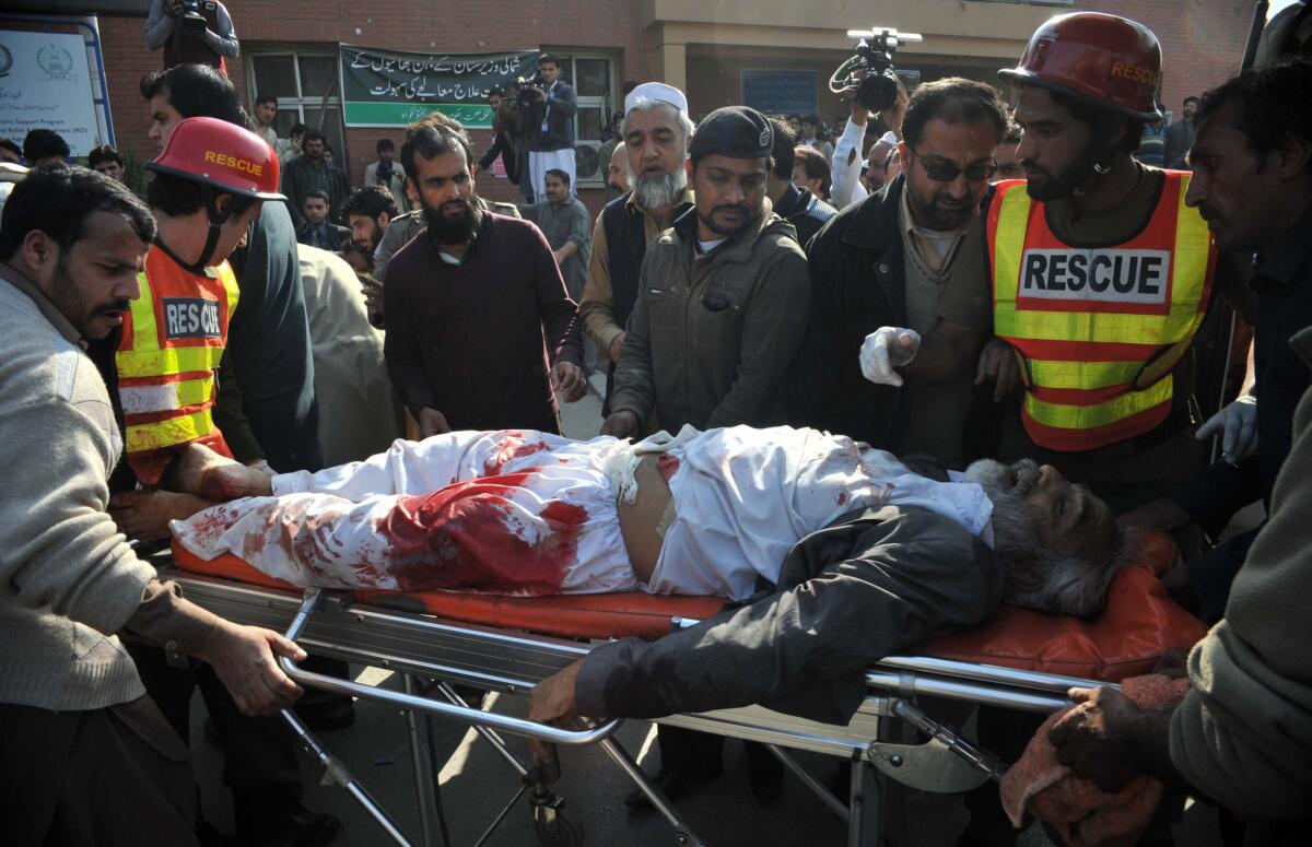 Rescue workers move an injured person to a hospital after a Taliban attack on a Shiite mosque in Peshawar, Pakistan, on Feb. 13.