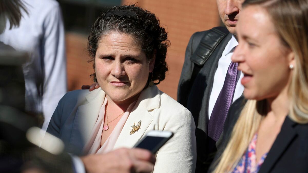 Nicole Eramo, left, listens to attorney Libby Locke speak with the media Friday after a jury found the magazine, its publisher and a reporter defamed Eramo in a discredited story about gang rape at a fraternity house at the University of Virginia.