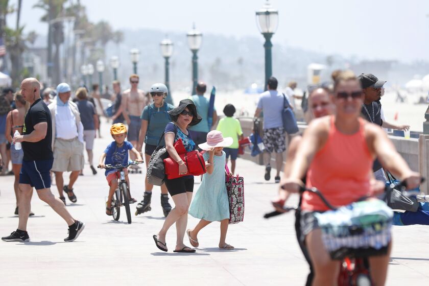 SAN DIEGO, CA - AUGUST 12: People walk along the boardwalk in Mission Beach on Thursday, August 12, 2021 in San Diego, CA. The U.S. Census Bureau released official 2020 data that shows San Diego remaining the 8th most populous, and a diverse city. (K.C. Alfred / The San Diego Union-Tribune)