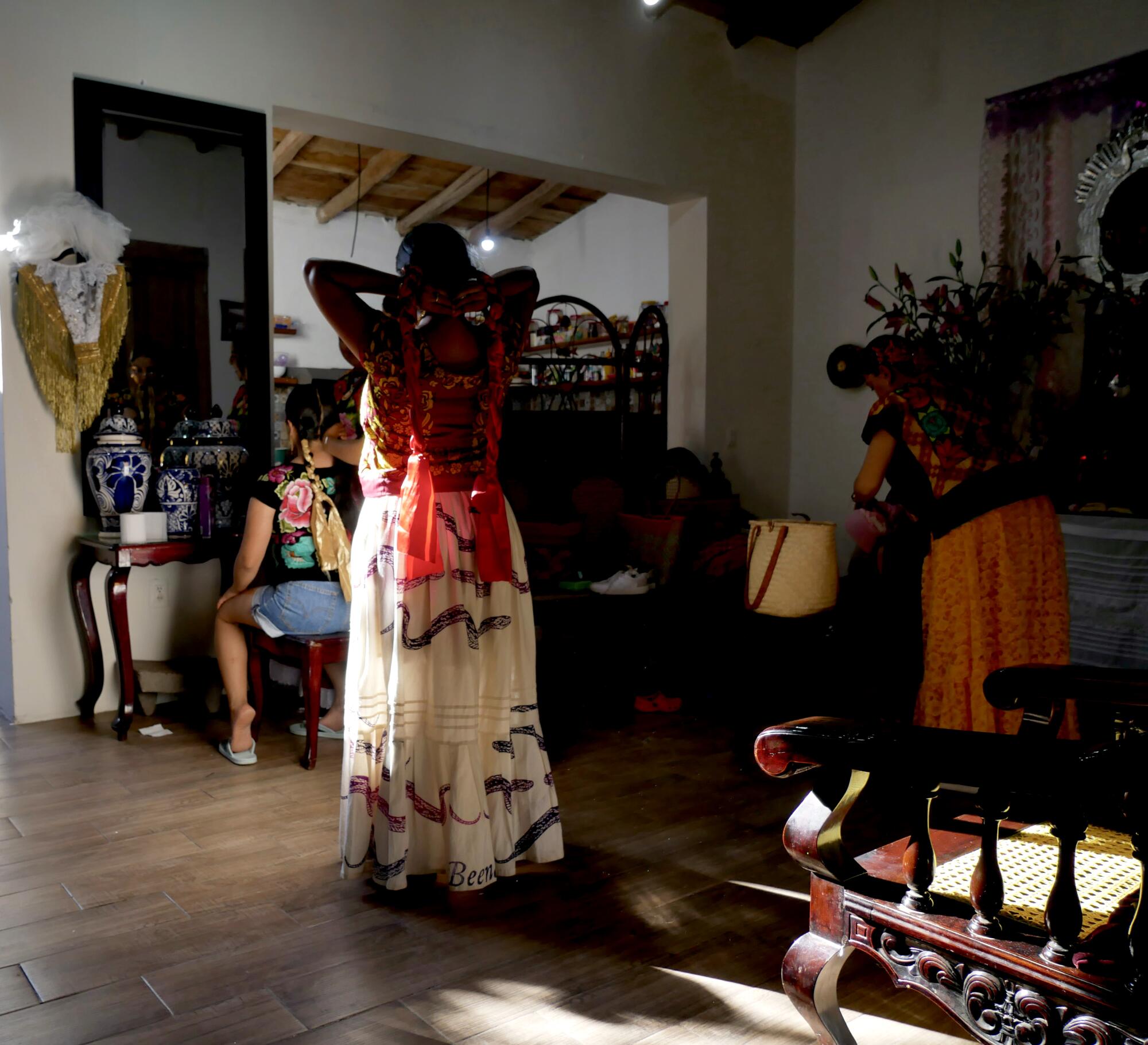 Two muxes make final outfit checks at home before joining the celebrations in Juchitan de Zaragoza