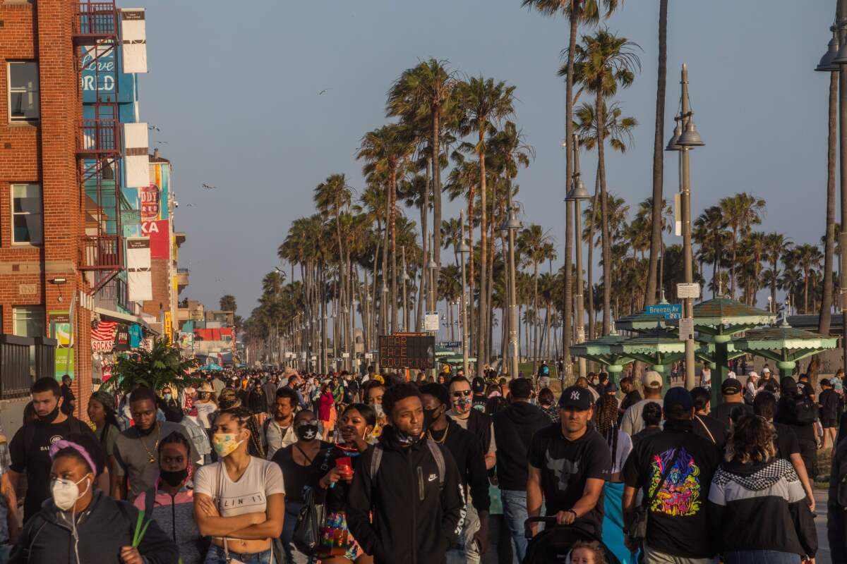 People fill the boardwalk in Venice Beach during the first day of the Memorial Day holiday weekend.