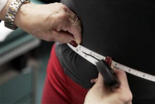 A subject's waist is measured during an obesity prevention study in Chicago. 