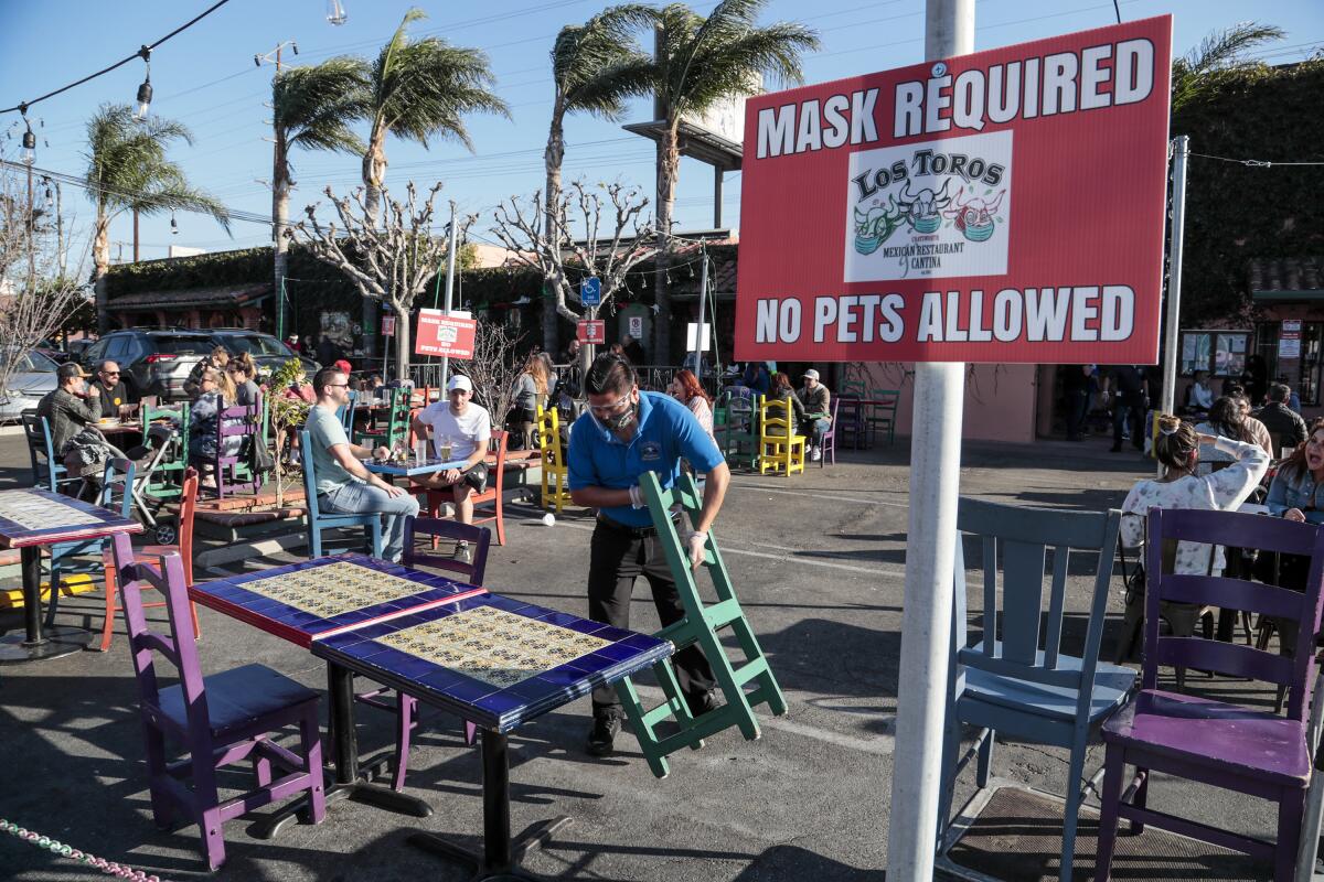 A "Mask Required" sign in the outdoor dining space of Los Toros Mexican Restaurant.