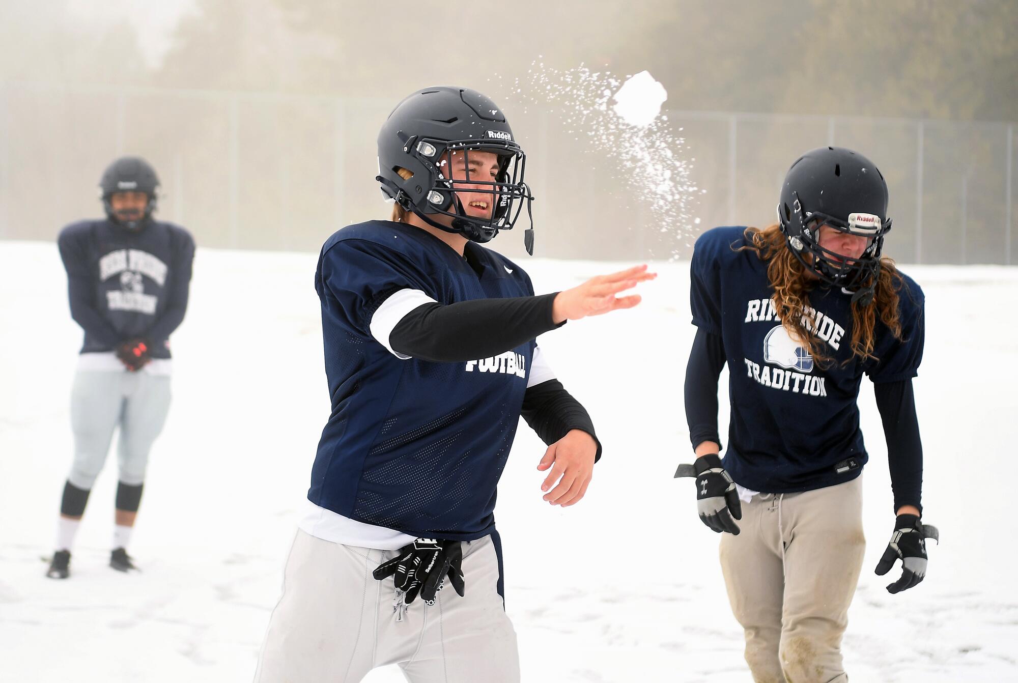Damon Lyons, center, throws a snowball before practice.