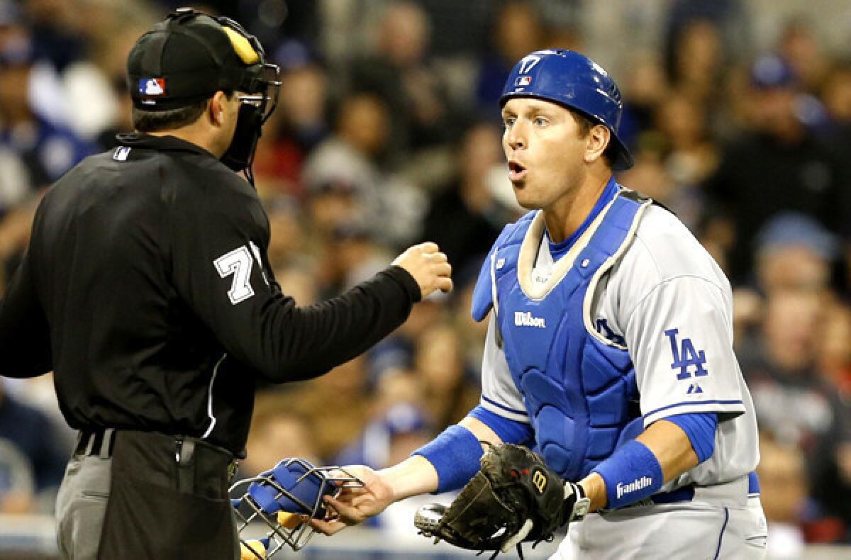 Dodgers catcher A.J. Ellis challenges the interference call of umpire Jim Reynolds in the fourth inning of a game against the Padres on Wednesday night in San Diego.