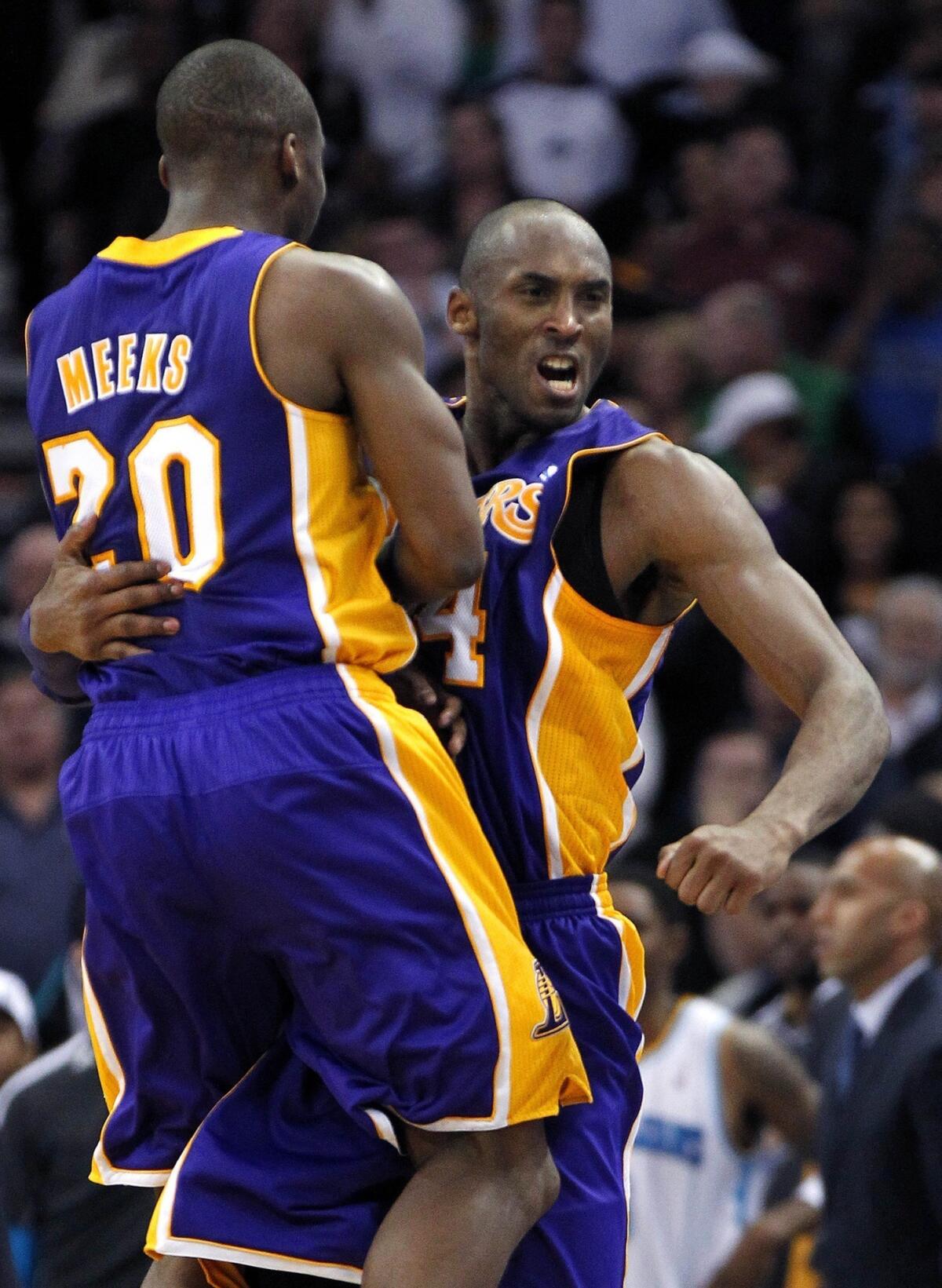 Lakers guard Kobe Bryant celebrates with teammate Jodie Meeks after his breakaway dunk against the New Orleans Hornets.