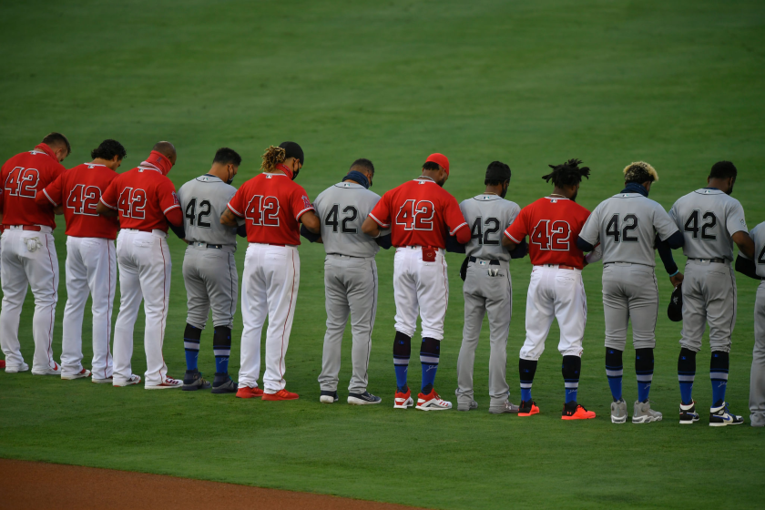 ANAHEIM, CA - AUGUST 28: Seattle Mariners and Los Angeles Angels players lock arms in shallow center field.