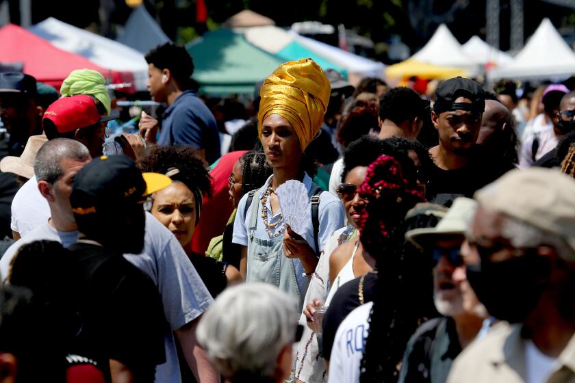 LOS ANGELES, CA - JUNE 19: Crowds of people converge on Degnan Boulevard for Juneteenth festivities in Leimert Park on Saturday, June 19, 2021. (Luis Sinco / Los Angeles Times)
