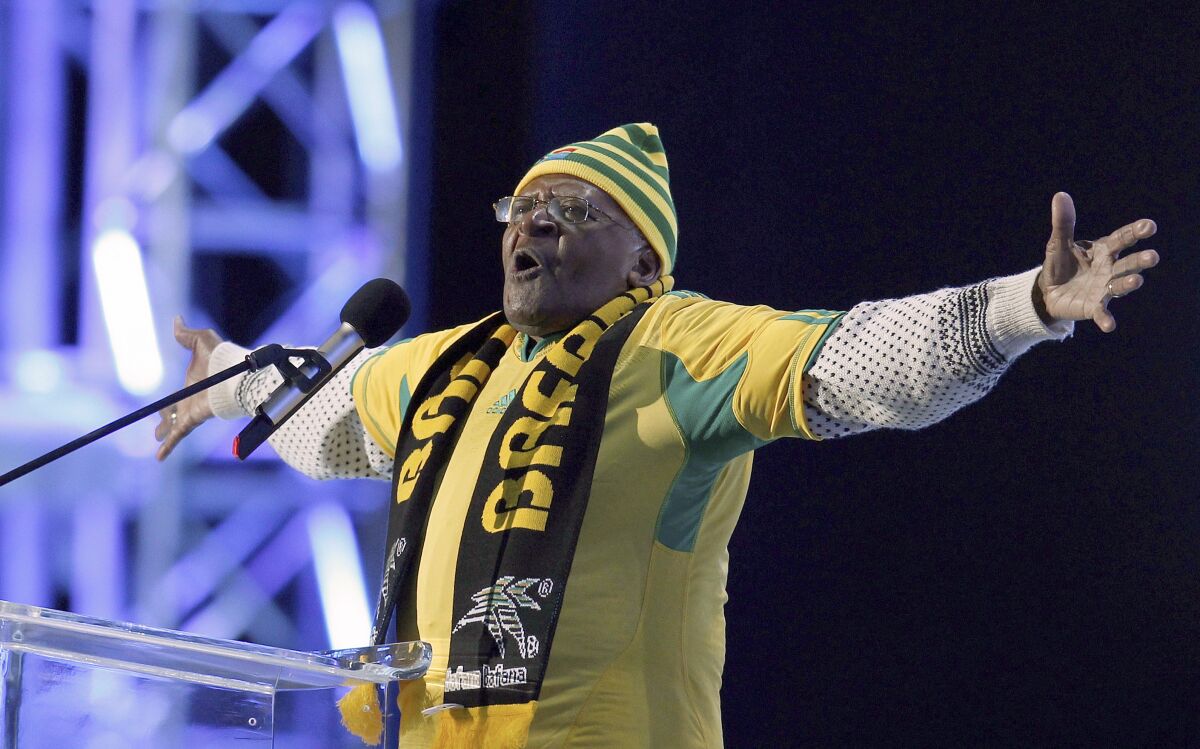 Desmond Tutu of South Africa gestures at a podium