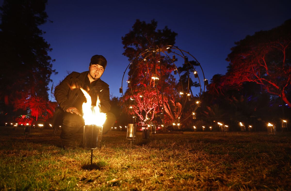 Pyrotechnic supervisor Anthony Delzio lights a lantern in the Fire Garden at San Diego Botanic Garden. 