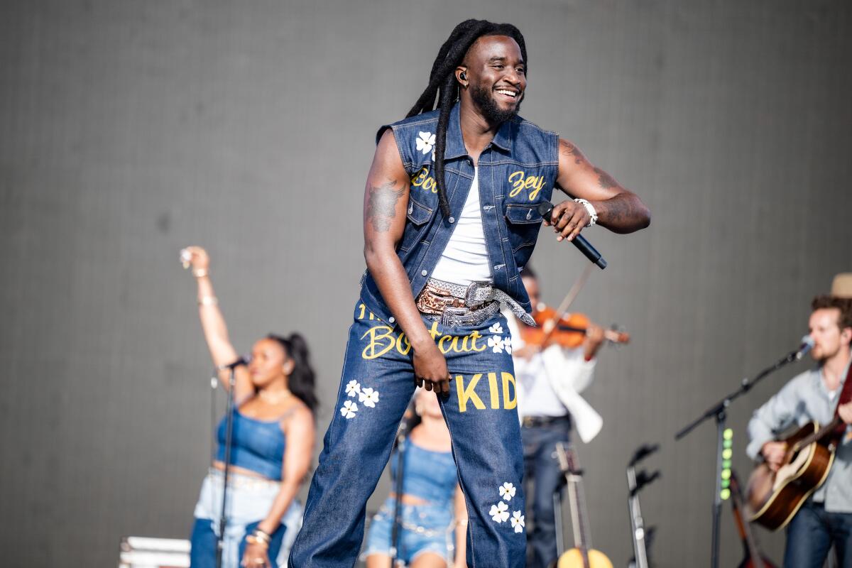 Shaboozey grins onstage.