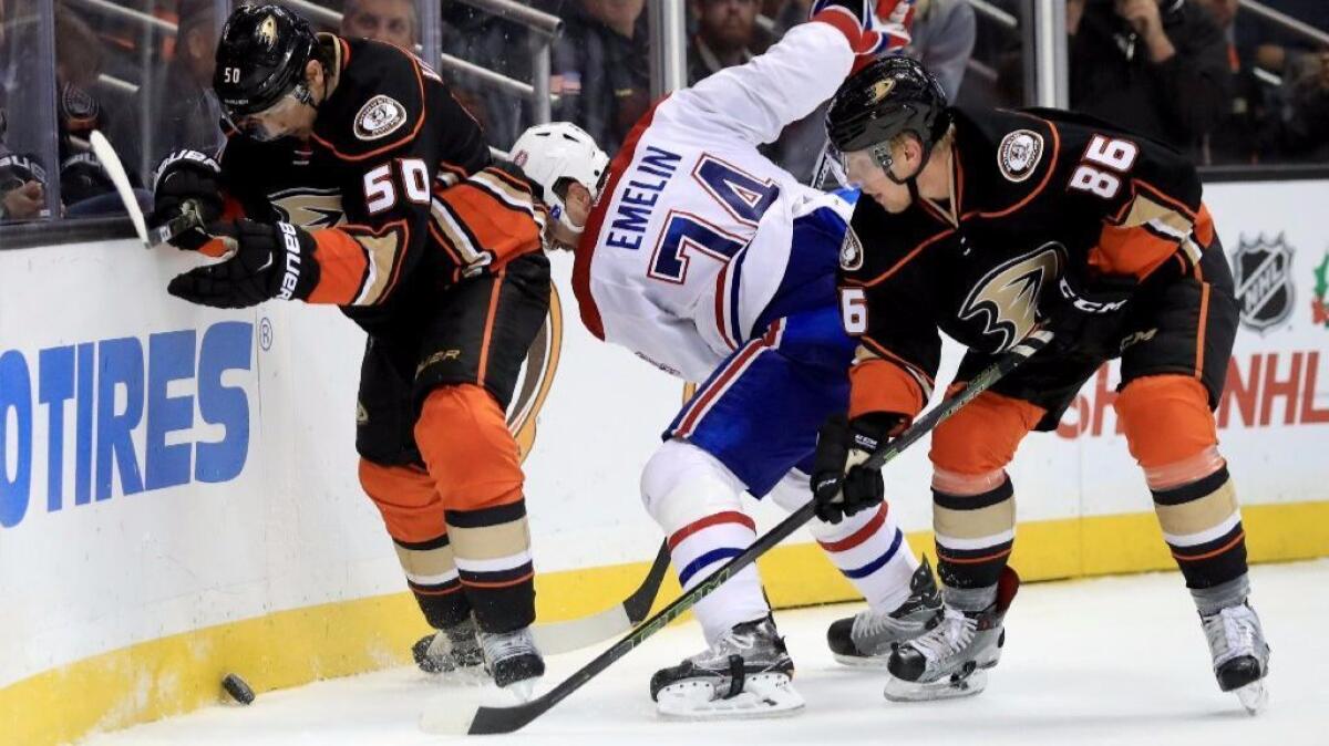 Ducks forwards Antoine Vermette, left, and Ondrej Kase battle Canadiens defenseman Alexei Emelin for a loose puck during the third period of a Nov. 29 game.