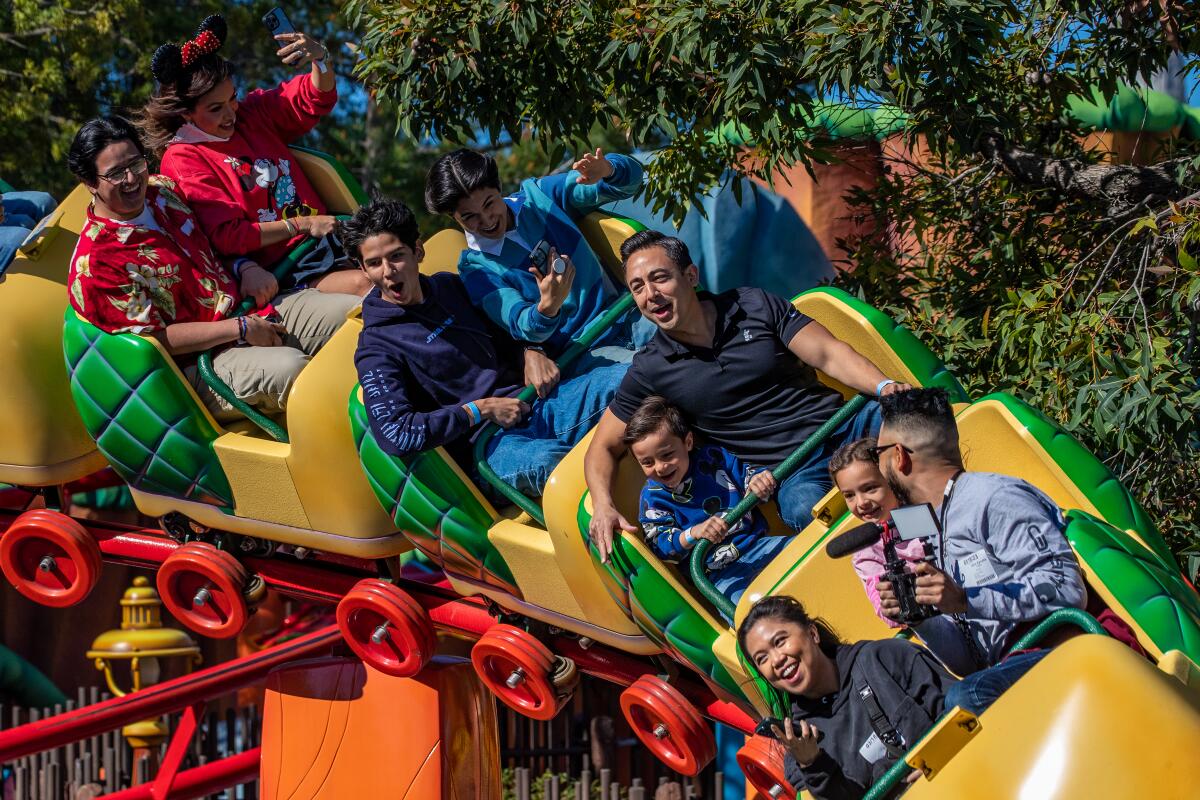 Laughing children and adults riding on a junior roller coaster
