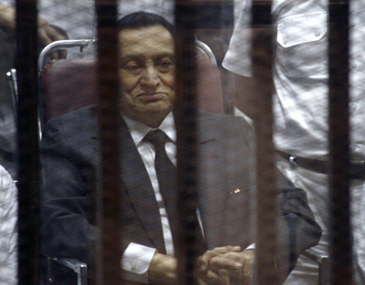 Ousted Egyptian President Hosni Mubarak sits in the defendants' cage, behind protective glass, during a court hearing in Cairo on May 21.