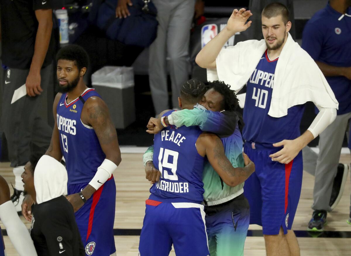 Rodney McGruder is hugged by Clippers teammate Patrick Beverley after making a three-point shot against the Trail Blazers.