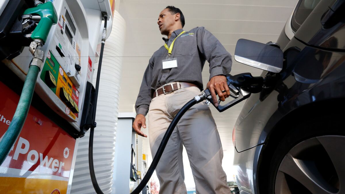 A man fills up his car's gas tank in Sacramento in 2014.