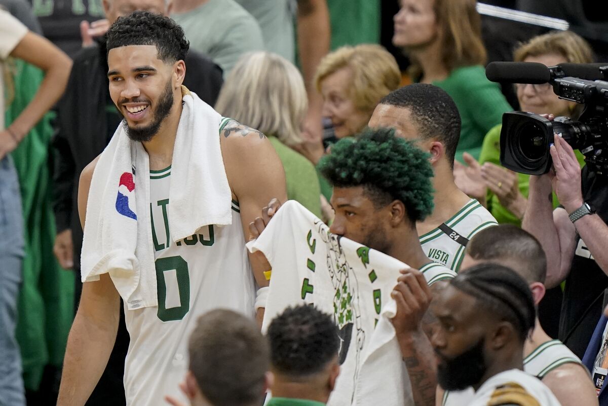Boston Celtics forward Jayson Tatum (0) and guard Marcus Smart (36) react at the end of Game 3 of basketball's NBA Finals against the Golden State Warriors, Wednesday, June 8, 2022, in Boston. (AP Photo/Steven Senne)