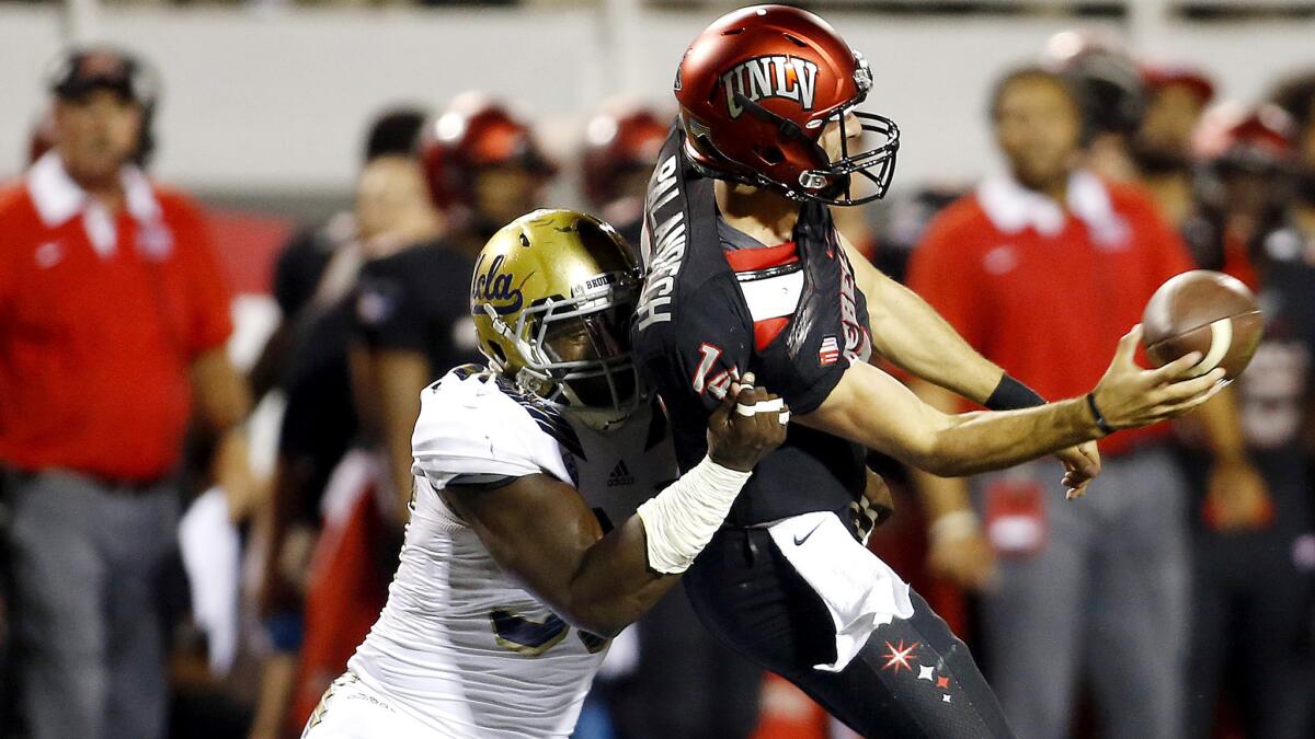 UCLA defensive lineman Takkarist McKinley pressures UNLV quarterback Kurt Palandech as he tries to pass in the first half Saturday.