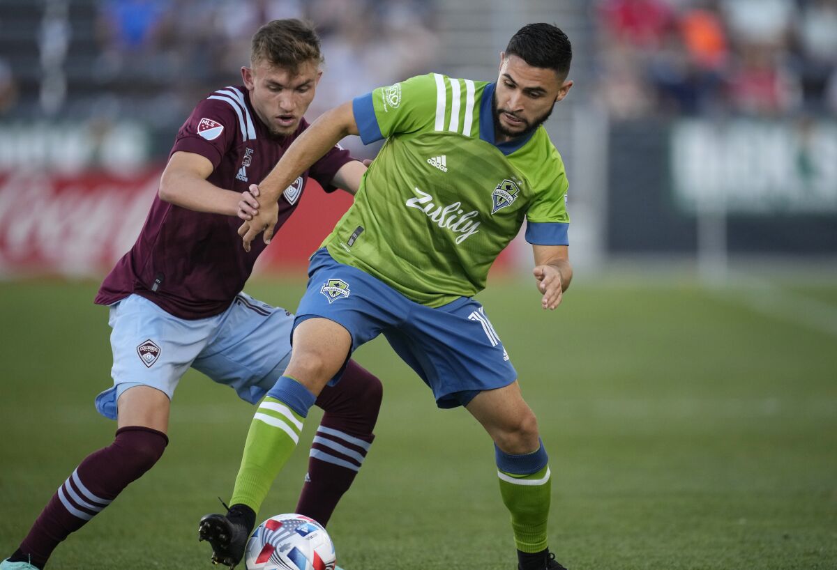 Seattle Sounders midfielder Alex Roldan, right, battles for control of the ball with Colorado Rapids defender Sam Vines in the first half of an MLS soccer match, Sunday, July 4, 2021, in Commerce City, Colo. (AP Photo/David Zalubowski)