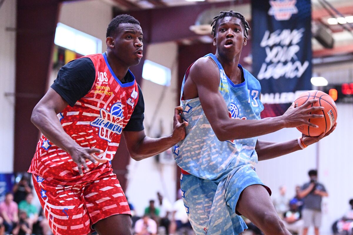 Vince Iwuchukwu, right, drives to the basket during the Pangos All-American Camp in June 2021.