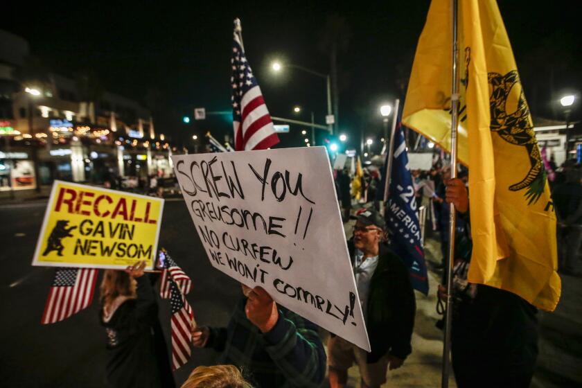 Huntington Beach, CA, Saturday, November 21, 2020 - As Covid-19 cases reach record numbers in the U.S. and California, hundreds gather at the pier and Pacific Coast Highway to protest a State mandated curfew of 10 pm. (Robert Gauthier/ Los Angeles Times)