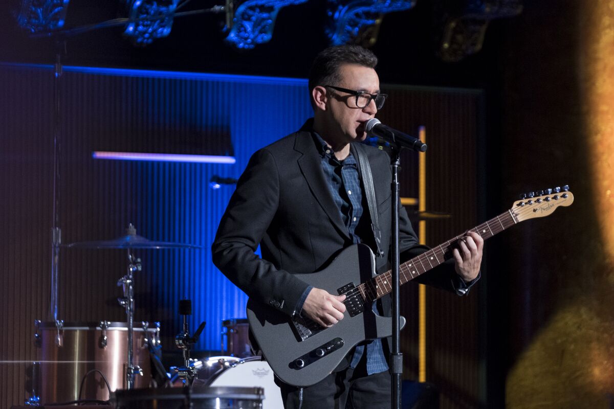A man on stage holding a guitar