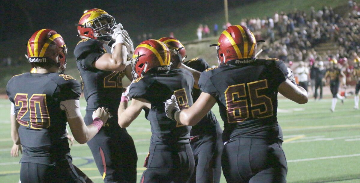 Junior Marco Notarainni (second from left) celebrates with teammates after scoring the game's first touchdown.