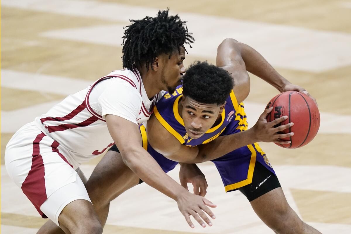 LSU's Cameron Thomas, right, is closely guarded by Arkansas' Desi Sills on March 13, 2021.