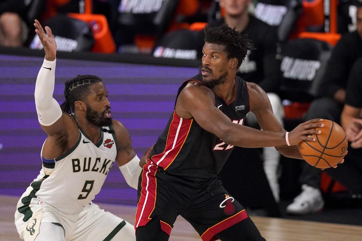 Milwaukee Bucks' Wesley Matthews defends as Miami Heat's Jimmy Butler handles the ball.