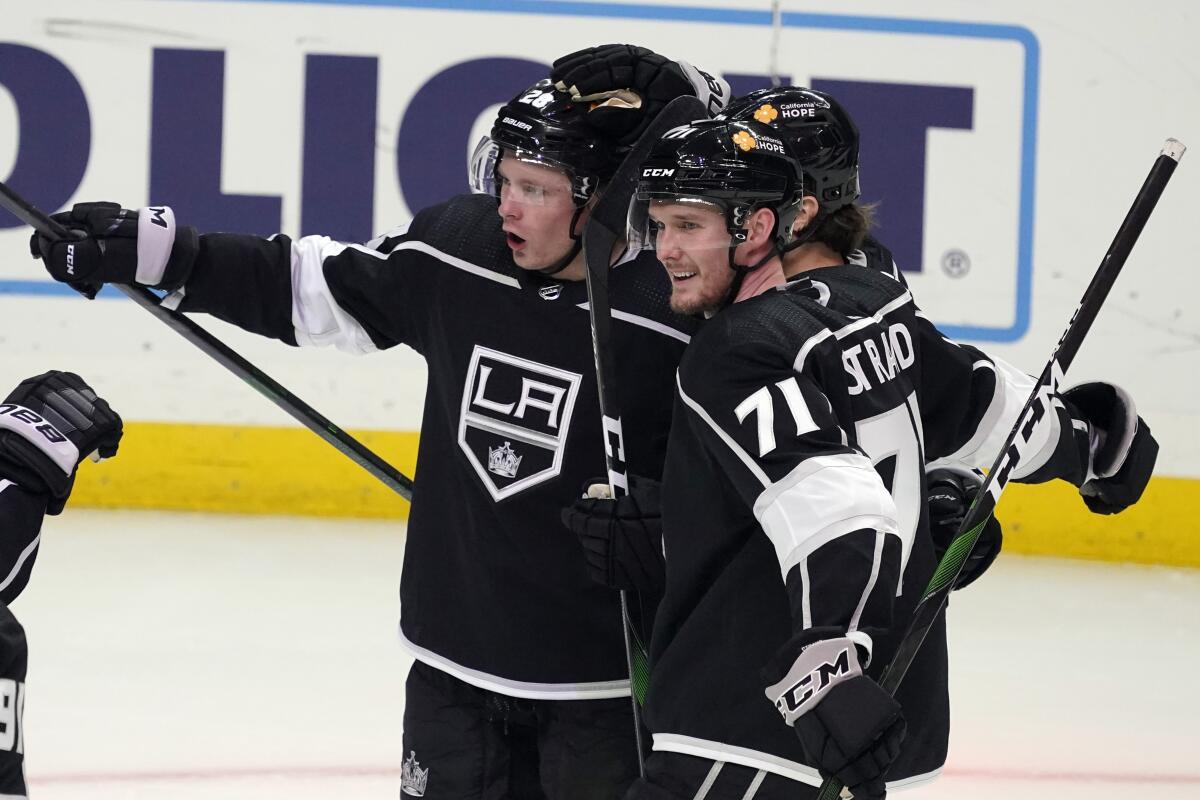 Kings center Jaret Anderson-Dolan is hugged by teammates.