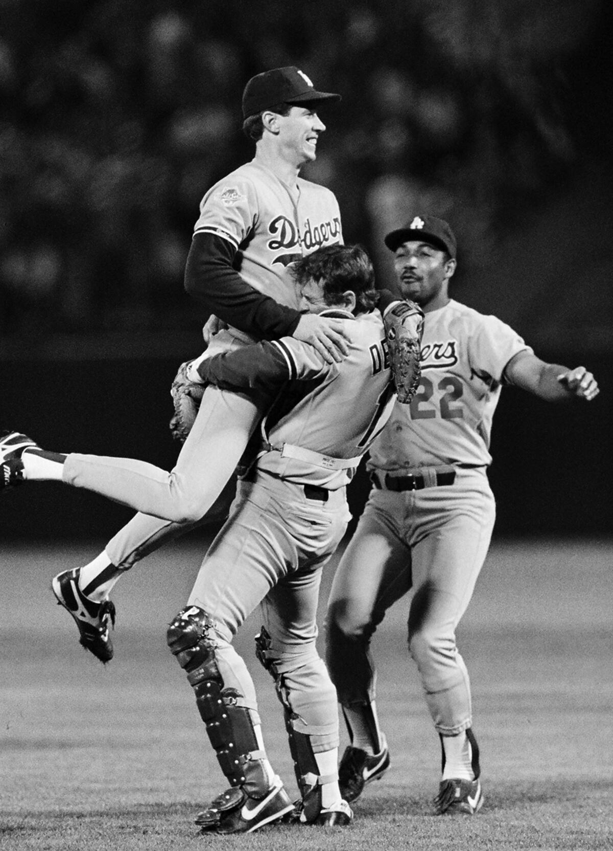 Rick Dempsey lifts Orel Hershiser, as Franklin Stubbs looks on at right, after the Dodgers beat the Oakland Athletics in Game 5 to win the 1988 World Series.