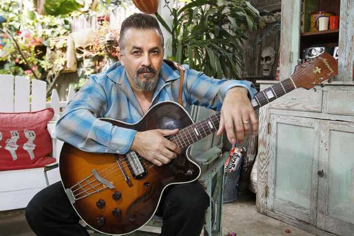 David "Kid" Ramos, 54, an electric blues and rock guitarist, and a singer and songwriter, poses for a photo at his home in Anaheim on Wednesday, May 8. Ramos, currently battling cancer, will be the recipient of a benefit show at the OC Marketplace this weekend.