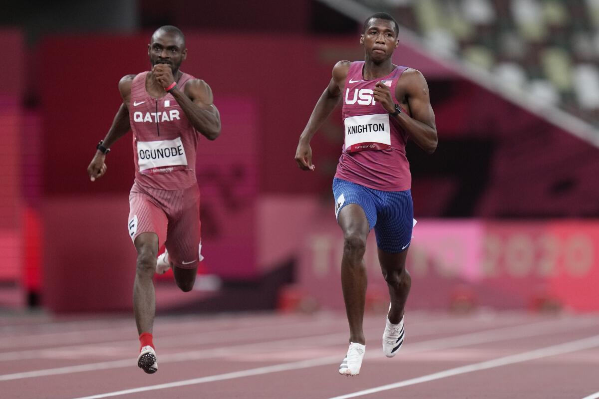 U.S. sprinter Erriyon Knighton, right, and Qatar's Femi Ogunode race to the finish line in a men's 200-meter semifinal.