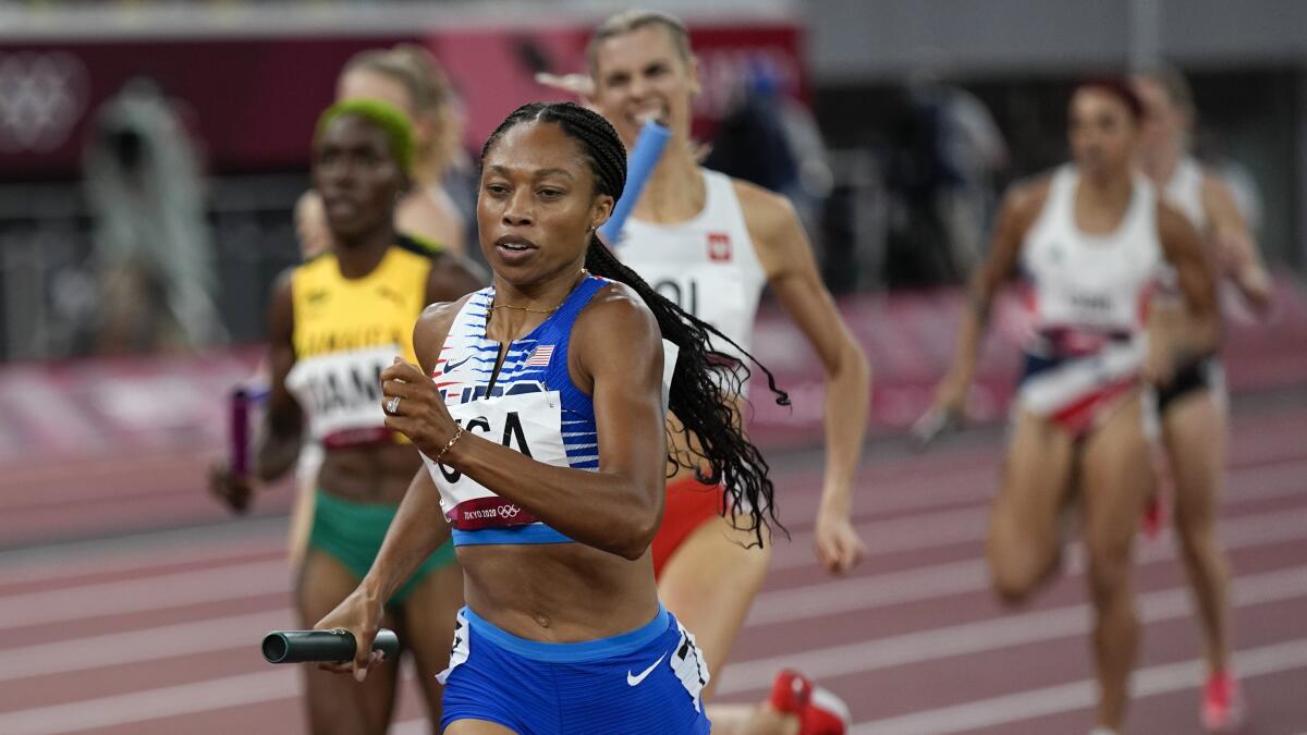 Allyson Felix runs with the baton.