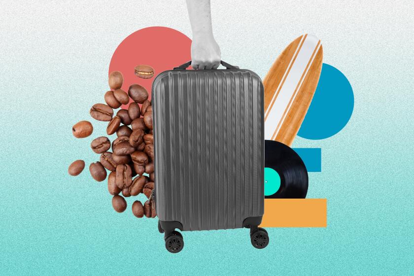 Suitcase in front of coffee beans, a surf board, and a vinyl.