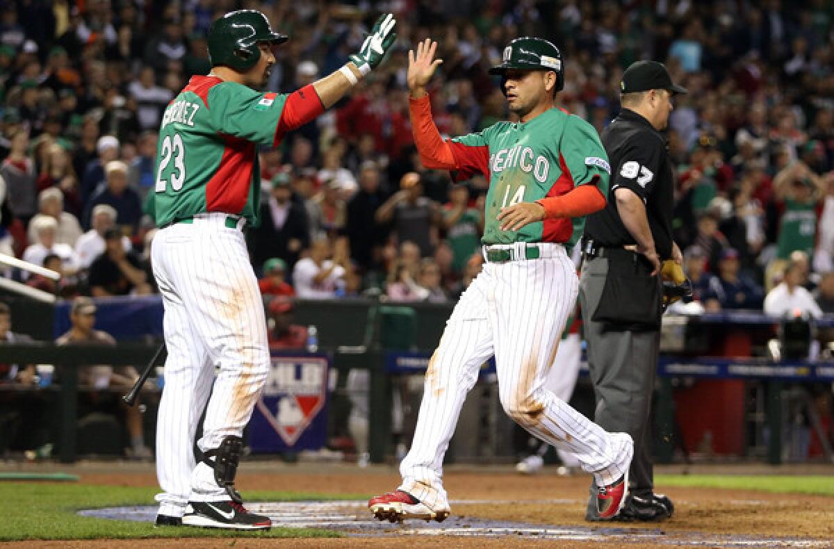 Adrian Gonzalez, left, greets Mexican squad teammate Eduardo Arredondo at the plate. With Mexico eliminated from the World Baseball Classic, Gonzalez will return to the Dodgers on Monday.