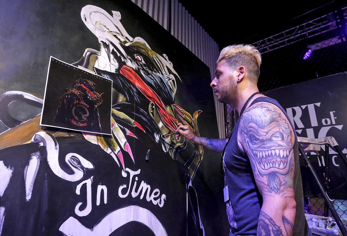 Artist Angel Acordagoitia illustrates an album cover during a live painting expo at the Art of Music Experience on Thursday.