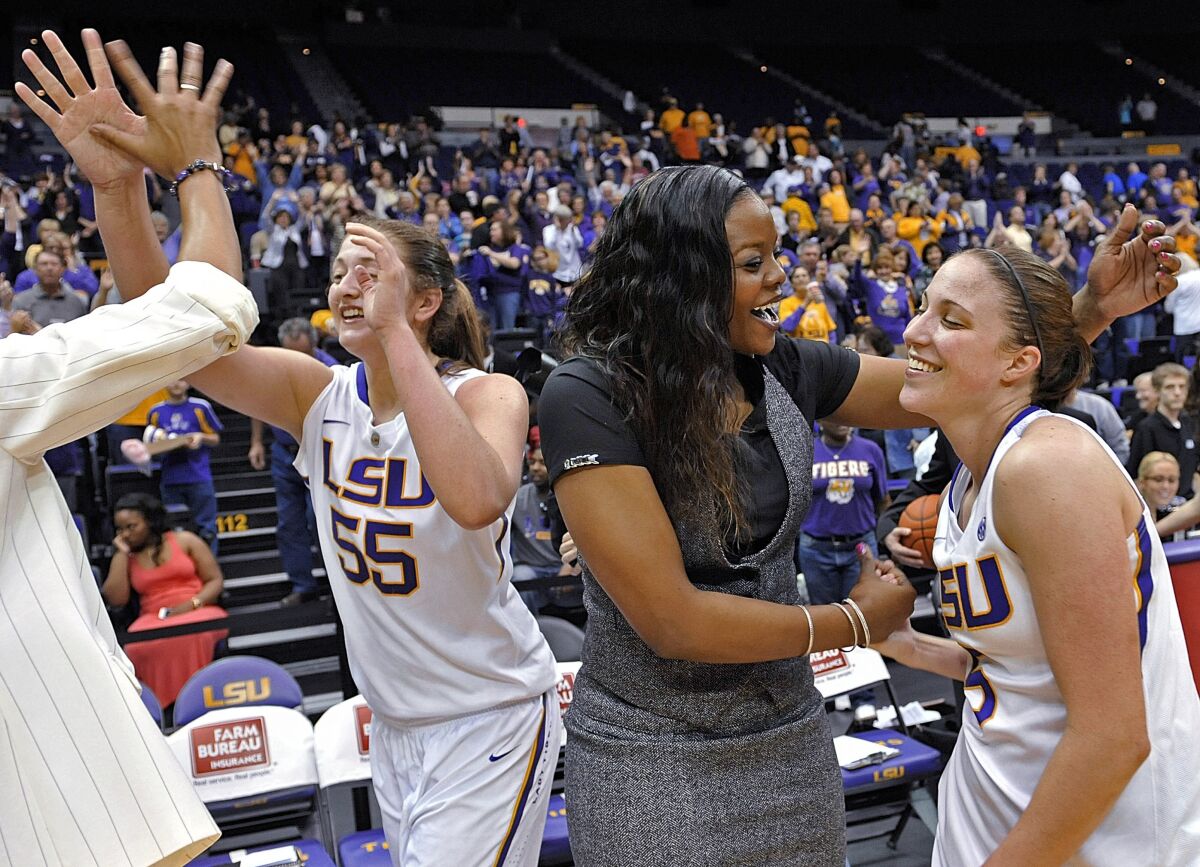 FILE - LSU's Theresa Plaisance (55) walks past as assistant coach Tasha Butts celebrates the team's win over Kentucky with guard Jeanne Kenney after an NCAA college basketball game in Baton Rouge, La., Feb. 24, 2013. Butts, now Georgia Tech associate head coach, said Wednesday, Dec. 8, 2021, she has been diagnosed with advanced-stage breast cancer. The 39-year-old Butts said she was diagnosed last month. She intends to keep coaching as much as possible while she's being treated. (AP Photo/Bill Feig, File)