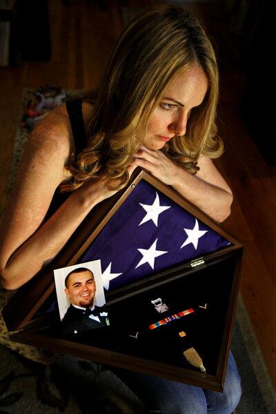 Megan Griffin is the widow of Michael Griffin (pictured lower left), who committed suicide in 2009, eight months after enlisting in the Army. Megan Griffin holds a flag that was used at his funeral.