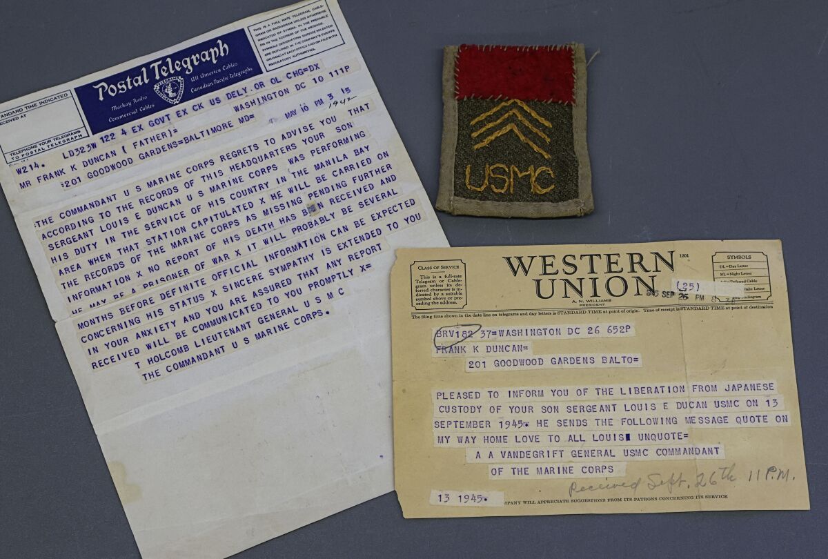 Telegrams reporting Louis Duncan's capture and liberation during World War II and a patch Duncan sewed himself.